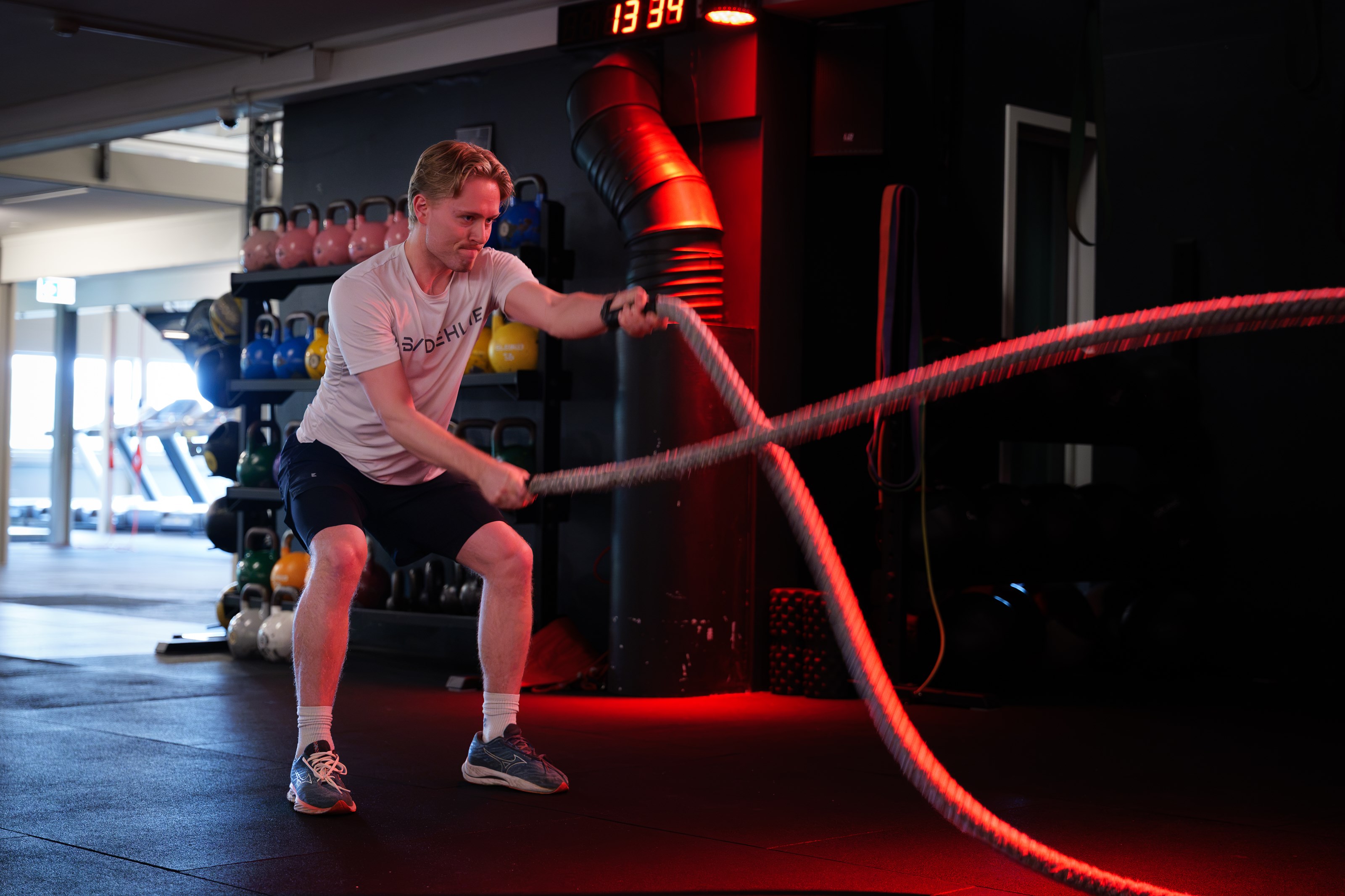 Medlem som trener med battle ropes hos Sporty
